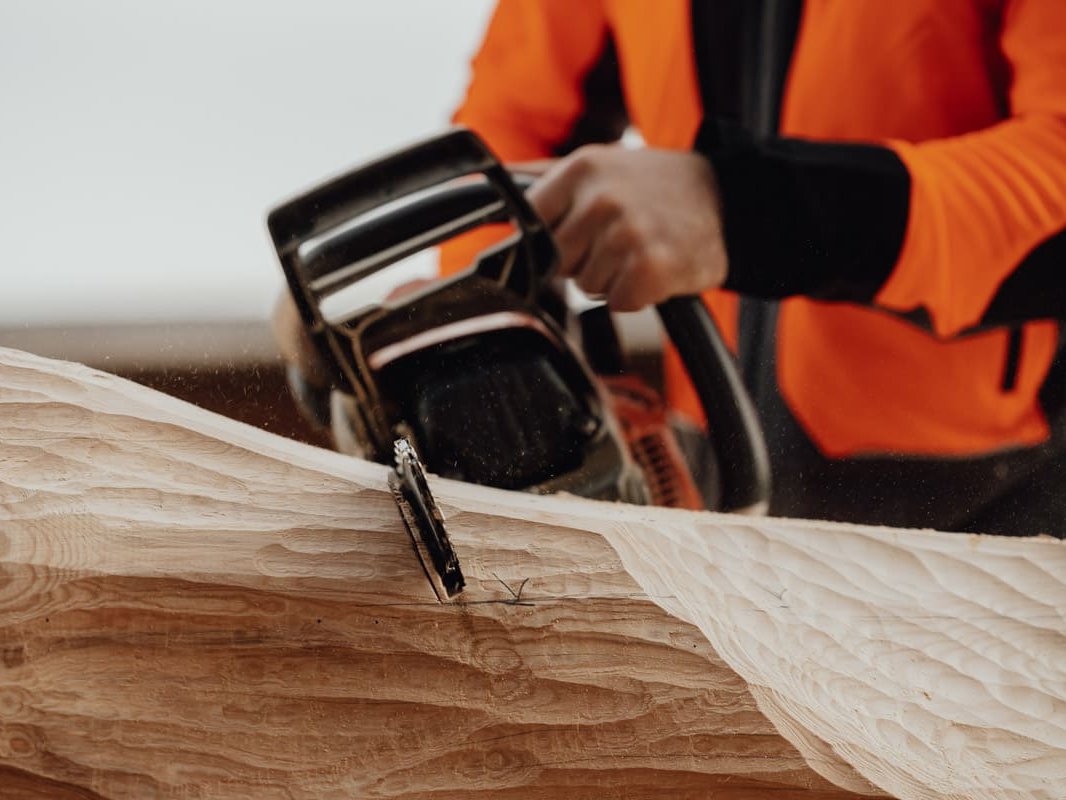 Mitarbeiter mit Motorsäge beim Blockhausbau