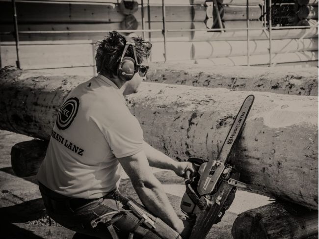 Mitarbeiter mit Säge bei Blockhausbau