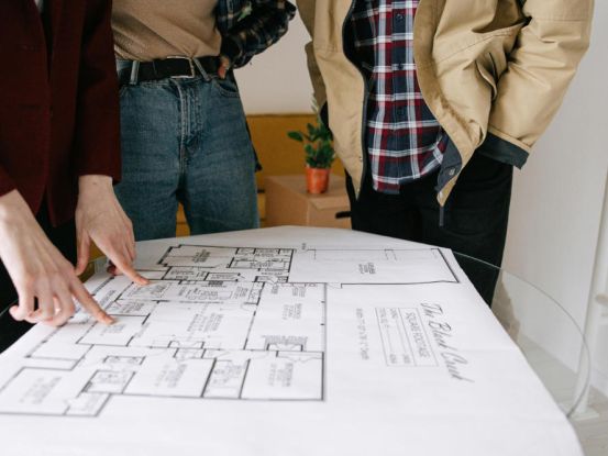 Grundrissplanung eines Naturstammhauses liegt auf einem Tisch